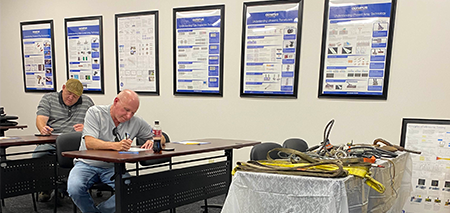 Employees taking notes in a CMAA Overhead Crane Operator training course.