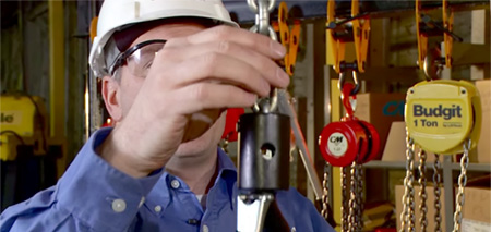 OSHA inspector analyzing hoist chain during an equipment inspection.