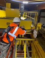 TSOC service technician performing annual inspection on a crane with an anti-collision device.