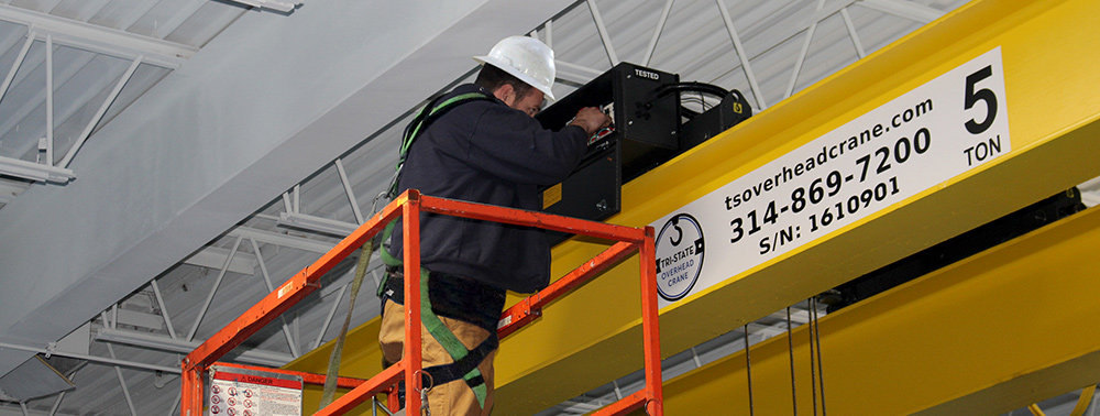 TSOC technician performing service on electrical components of a hoist on a 5 ton overhead bridge crane.