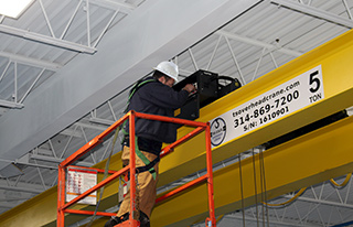 TSOC technician performing service on electrical components of a hoist on a 5 ton overhead bridge crane.